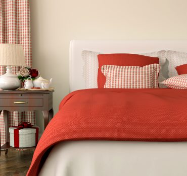 Bedroom decorated in red bedspread and curtains in Christmas style